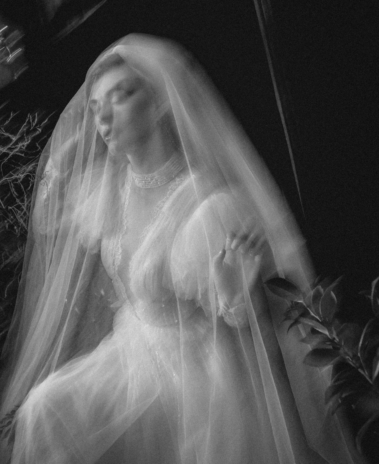 Bride moving beneath layers of translucent veil